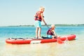 Two brothers swimming on stand up paddle board.Water sports , active lifestyle.