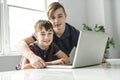 Two brothers using laptop computer to do their homework Royalty Free Stock Photo