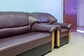 Two brown chaise long sofas in the room with blue walls and wooden doors