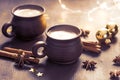 Two brown clay cups of black coffee, Christmas decoration, spices on the wooden table. Selective focus. Toned image