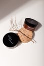 Two brown containers with tree branch and solid shadows on white. Face skin care cosmetics, mask,