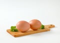 Two brown eggs on cutting board Royalty Free Stock Photo