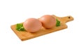 Two brown eggs on cutting board Royalty Free Stock Photo