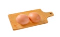 Two brown eggs on cutting board Royalty Free Stock Photo