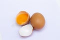 Two brown eggs There was one egg broken in half, with a yolk inside the eggshell and the egg whites flowing on a white background Royalty Free Stock Photo