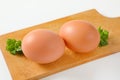 Two brown eggs on cutting board Royalty Free Stock Photo