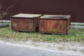 two brown iron rusty garbage cans stand in the green grass o Royalty Free Stock Photo