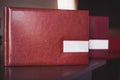 Two brown leather wedding photo album with engraving on the cover lie on a wooden table. Soft focus. Royalty Free Stock Photo