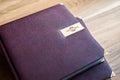 Two brown leather wedding photo album with engraving on the cover lie on a wooden table. Soft focus