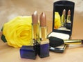 Two brown lipsticks powder and yellow rose Royalty Free Stock Photo