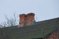 Two brown old chimneys on a slate green roof Royalty Free Stock Photo