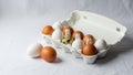 Two brown and one white egg are positioned outside the carton Royalty Free Stock Photo