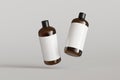 Two brown plastic cosmetic containers with labels, shampoo bottles floating on gray background front view 3D render