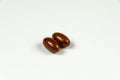 Two brown soft gelatine capsules.