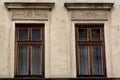 Two brown wooden Windows on the facade of the old dirty house