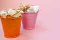 Two buckets filled with seashells on a pink background. Orange and pink bucket. There is a place for text Royalty Free Stock Photo