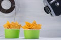 Two buckets with nachos, on a gray background, next to an old video camera and a film Royalty Free Stock Photo