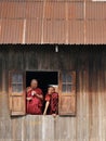 Two Buddhist monks chatting at window while watching Phaung Daw Oo festival, Inle Lake, Myanmar Burma