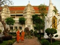 Two Buddhist monks pose in the gardens of the Royal Cemetery next to the Wat Ratchabophit temple in Bangkok, Thailand