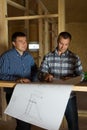 Two builders checking a blueprint together