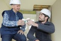 Two builders in hardhat taking coffee break Royalty Free Stock Photo