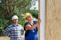 Two builders installing insulated wall panels Royalty Free Stock Photo