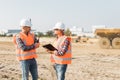 Builders in orange vests and helmets working on the road construction field Royalty Free Stock Photo