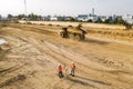 Builders in orange vests and helmets working on the road construction field Royalty Free Stock Photo