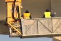 Two builders in yellow at the construction site work on crane Royalty Free Stock Photo