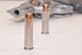 Two bullets in front of a loaded revolver Royalty Free Stock Photo