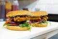 Two burgers with breaded chicken fillet in a restaurant kitchen Royalty Free Stock Photo