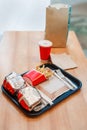 Two burgers wrapped in tinfoil, french fries potato chips, red cup of coffee Royalty Free Stock Photo