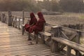 Two Burmese monks seating on U Bein Bridge