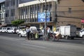 Two burmese people transports heavy bags and boxes by bike in traffic