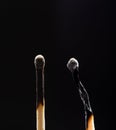 Two burned out wooden matches on black Royalty Free Stock Photo