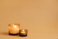 Two burning aroma candles with ginger scent on orange background