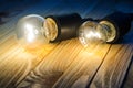 Two burning bulbs on a wooden table Royalty Free Stock Photo