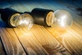 Two burning bulbs on a wooden table Royalty Free Stock Photo