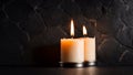 Two burning candles dark stone background Royalty Free Stock Photo