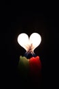 Two burning candles with a flame in the form of a heart on a black background Royalty Free Stock Photo