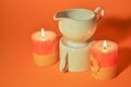 Two burning candles and a porcelain kettle