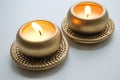 Two burning decorative candles in gold color