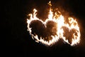 Two burning hearts at night, flame in the shape of sparkling love sign