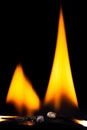 Two burning matchsticks against a black background Royalty Free Stock Photo