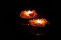 Two burning pooja candles at night on the river Ganges