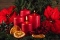 Two burning Red advent candles in advent wreath decoration on wooden dark background Royalty Free Stock Photo