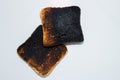 Two burnt toasts - slices of toast bread isolated on a white background. Royalty Free Stock Photo