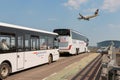 Two buses on the way to London Heathrow airport terminal while Lufthansa passenger plane landing Royalty Free Stock Photo