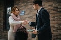 Business associates shaking hands outdoors with a professional demeanor Royalty Free Stock Photo