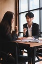 Business colleagues analyzing documents together in meeting room.